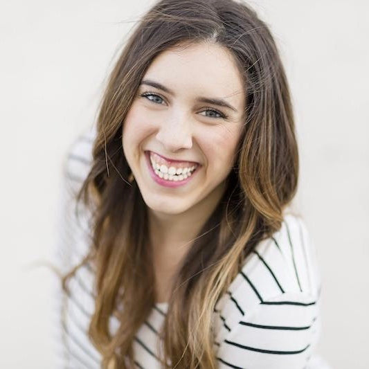 Christina Scalera in black and white striped shirt smiling big