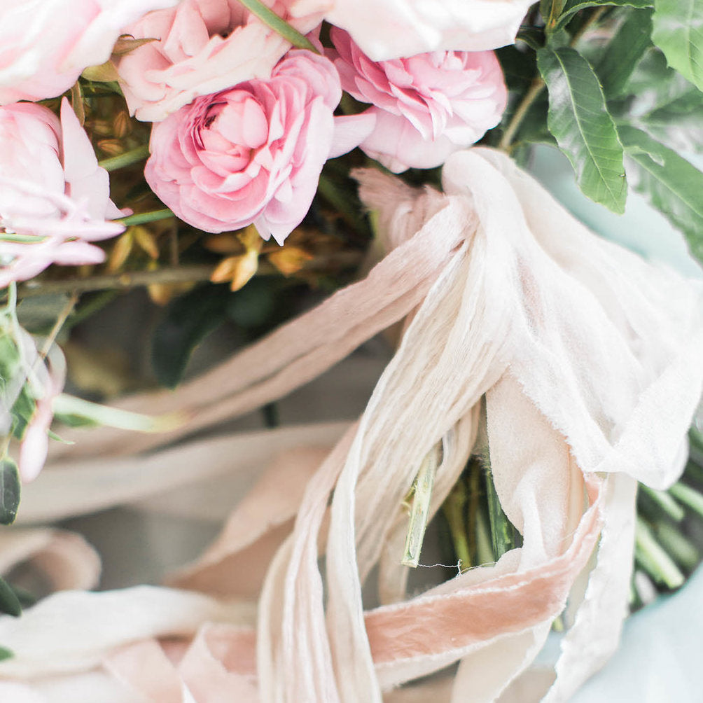Long stemmed bouquet of pink peonies wrapped with light pink cloth