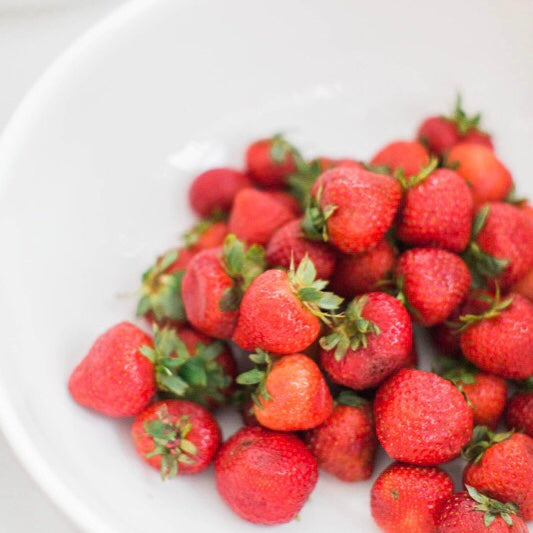 white bowl full of red strawberries