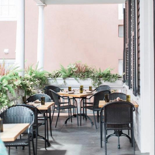 Outside seating area at cafe, black metal chairs and wooden tables